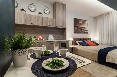 a bedroom with a bed and a table with plates of food at Raugyklos apartamentai in Vilnius