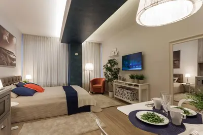 a bedroom with a king sized bed and a living room at Raugyklos apartamentai in Vilnius