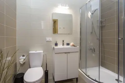 a bathroom with a toilet and a sink and a shower at Raugyklos apartamentai in Vilnius