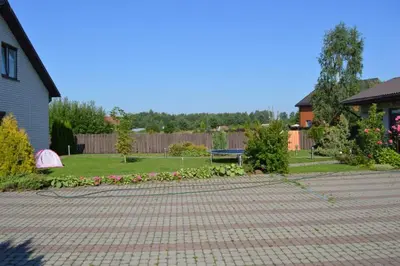 a backyard with a brick patio and a bench at Cottage with fireplace and sauna in Pakalniškės