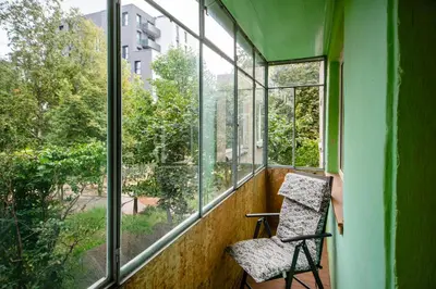 a chair sitting in a room with a window at Urban Escape Kaunas - Quiet Apartment 5 km from City Center in Kaunas