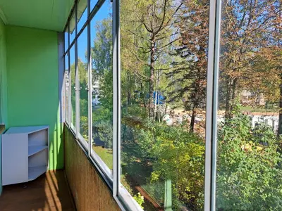 two windows in a room with a view of trees at Urban Escape Kaunas - Quiet Apartment 5 km from City Center in Kaunas
