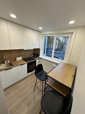 a kitchen with a table and chairs and a window at Moncerat in Šiauliai