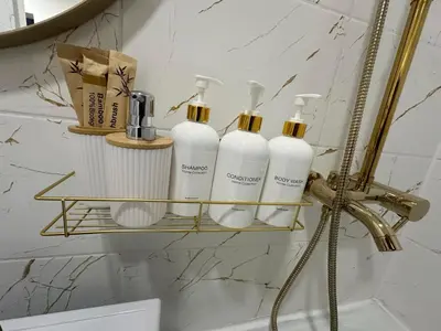 a group of four bottles on a shelf in a bathroom at Moncerat in Šiauliai