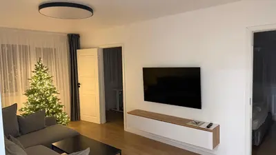 a living room with a television and a christmas tree at Moncerat in Šiauliai