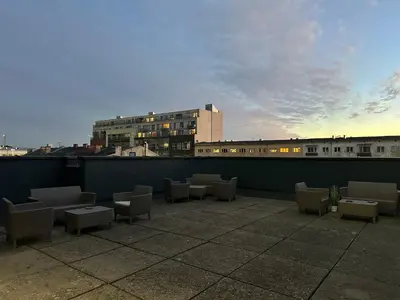 a patio with chairs and tables on a rooftop at Jaukus butas Kauno centre in Kaunas