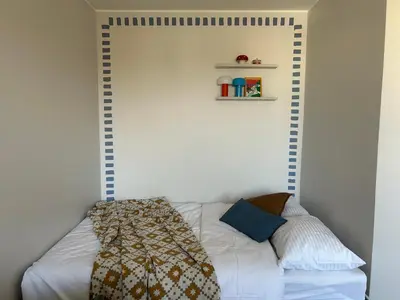 a bedroom with a white bed and a shelf at Cloud apartments in Alytus