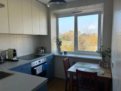a kitchen with a table and a large window at Cloud apartments in Alytus
