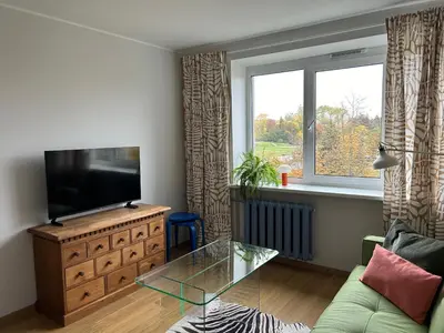 a living room with a television and a glass table at Cloud apartments in Alytus