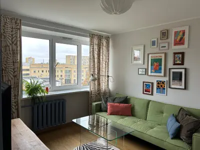 a living room with a green couch and a glass table at Cloud apartments in Alytus