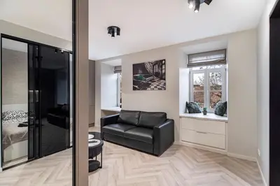 a living room with a black leather chair and a window at apartment with jacuzzi, old town in Vilnius