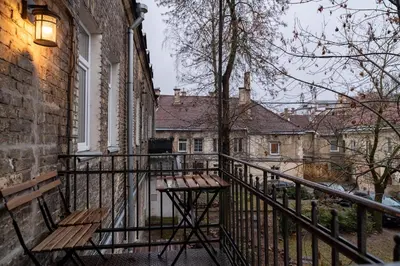 a balcony with a wooden bench next to a building at apartment with jacuzzi, old town in Vilnius