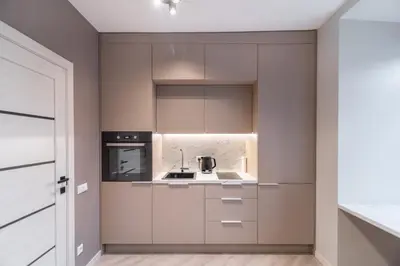 a kitchen with beige cabinets and a sink at apartment with jacuzzi, old town in Vilnius