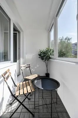 two chairs and a table in a room with windows at GoldenHugo Apartment in Vilnius