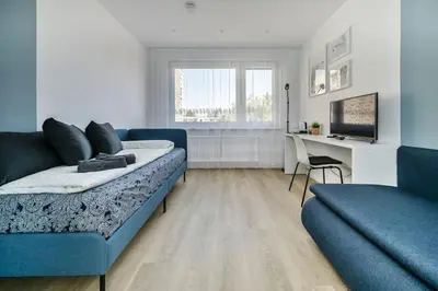 a living room with a blue couch and a desk at GoldenHugo Apartment in Vilnius
