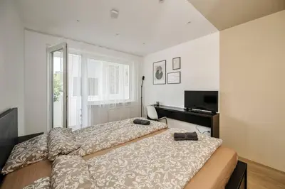 a bedroom with two beds and a television at GoldenHugo Apartment in Vilnius
