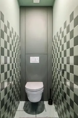 a bathroom with a toilet and a tiled wall at GoldenHugo Apartment in Vilnius