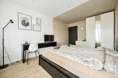 a bedroom with a large bed and a desk at GoldenHugo Apartment in Vilnius
