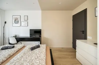 a bedroom with two beds and a desk at GoldenHugo Apartment in Vilnius