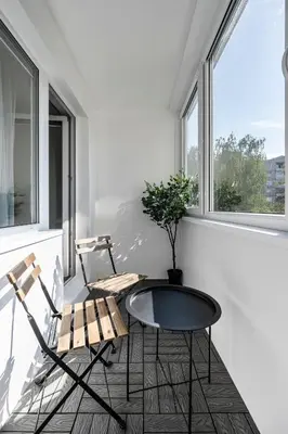 two chairs and a table in a room with windows at GoldenHugo rooms in Vilnius
