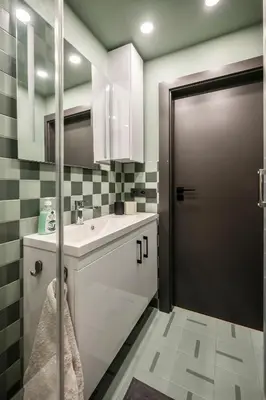 a bathroom with a white sink and a door at GoldenHugo rooms in Vilnius