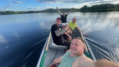 a group of people sitting in a boat on the water at Pas Žuvelį in Stariai
