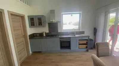 a kitchen with a stove and a sink and a window at Pas Žuvelį in Stariai
