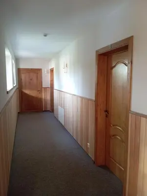 an empty hallway with wood paneling and a door at Sodyba Prie Tvenkinio in Kurtuvėnai