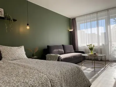 a living room with a bed and a couch at Moody apartments in Šiauliai