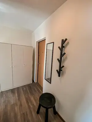 a room with a stool and a mirror on a wall at Moody apartments in Šiauliai