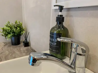 a bottle of wine sitting on top of a sink at Moody apartments in Šiauliai