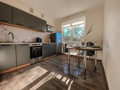 a kitchen with a table and a table and chairs at Moody apartments in Šiauliai