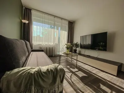 a living room with a couch and a flat screen tv at Moody apartments in Šiauliai