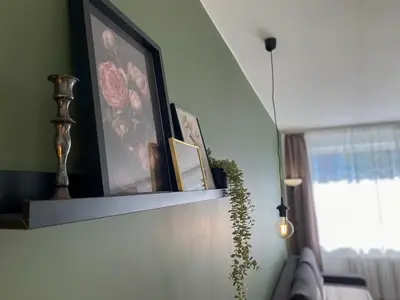 a living room with a shelf with pictures on it at Moody apartments in Šiauliai