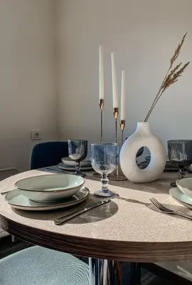 a table with plates and glasses on top of it at Moody apartments in Šiauliai