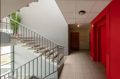 a hallway with stairs and a red door at Onas apartament 2 with private parking in Kaunas