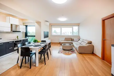 a kitchen and living room with a table and a couch at Onas apartament 2 with private parking in Kaunas