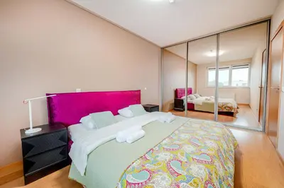a bedroom with a large bed and a large mirror at Onas apartament 2 with private parking in Kaunas