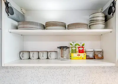 a shelf with plates and other items in a pantry at Onas apartament 2 with private parking in Kaunas