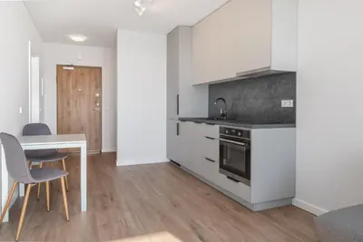a kitchen with white cabinets and a table and chairs at Two room Apartment - self check-in in Vilnius