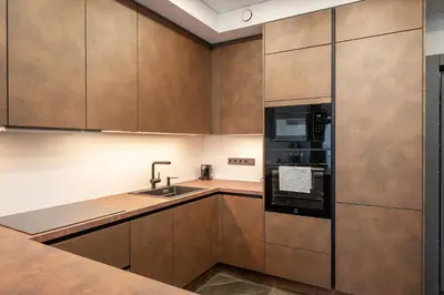 a kitchen with wooden cabinets and a sink and a microwave at Modern Oasis in Vilnius Center by Reside Baltic in Vilnius