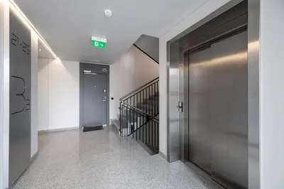 a hallway with a metal door and a stairway at Modern Oasis in Vilnius Center by Reside Baltic in Vilnius