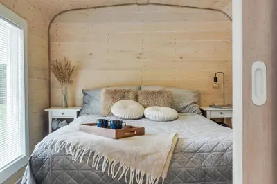 a bedroom with a bed with a wooden wall at Meldai in Pabradė