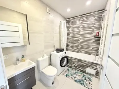 a bathroom with a toilet and a sink at Cozy Ozo apartments, free parking! in Vilnius