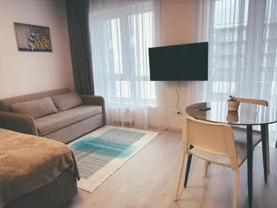 a small living room with a table and a couch at Cozy Ozo apartments, free parking! in Vilnius