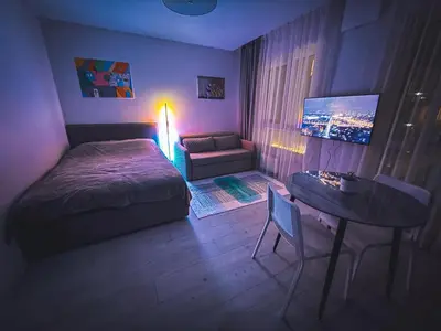 a bedroom with a bed and a table and a couch at Cozy Ozo apartments, free parking! in Vilnius