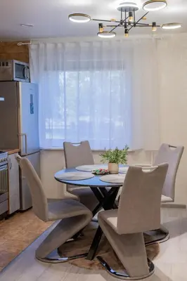 a dining room table and chairs in a kitchen at Malena Apartments in Šiauliai
