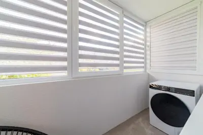 a laundry room with windows with blinds at Malena Apartments in Šiauliai