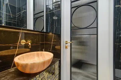 a bathroom with a wooden sink and a glass door at Apartment Gedimino 22 in Vilnius