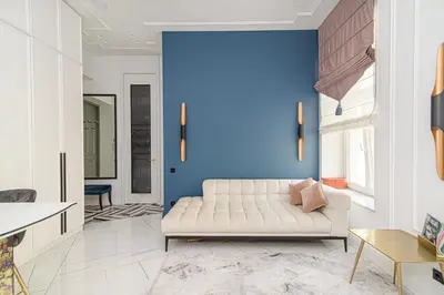 a living room with a white couch and a blue wall at Apartment Gedimino 22 in Vilnius